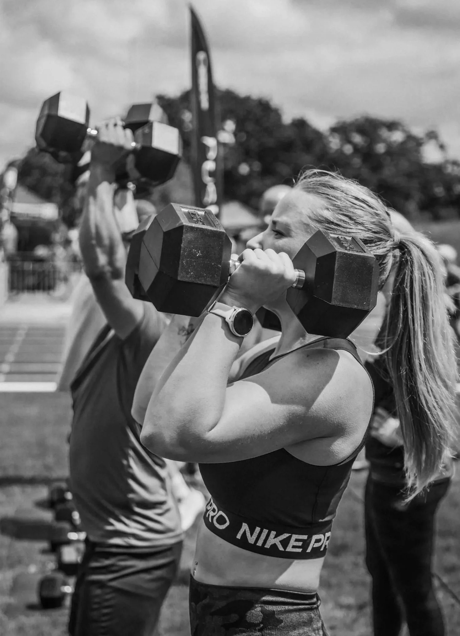 Athlète effectuant un « push press » avec deux haltères au-dessus de la tête